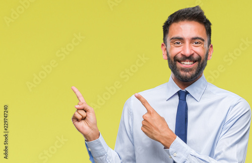 Adult hispanic business man over isolated background smiling and looking at the camera pointing with two hands and fingers to the side.
