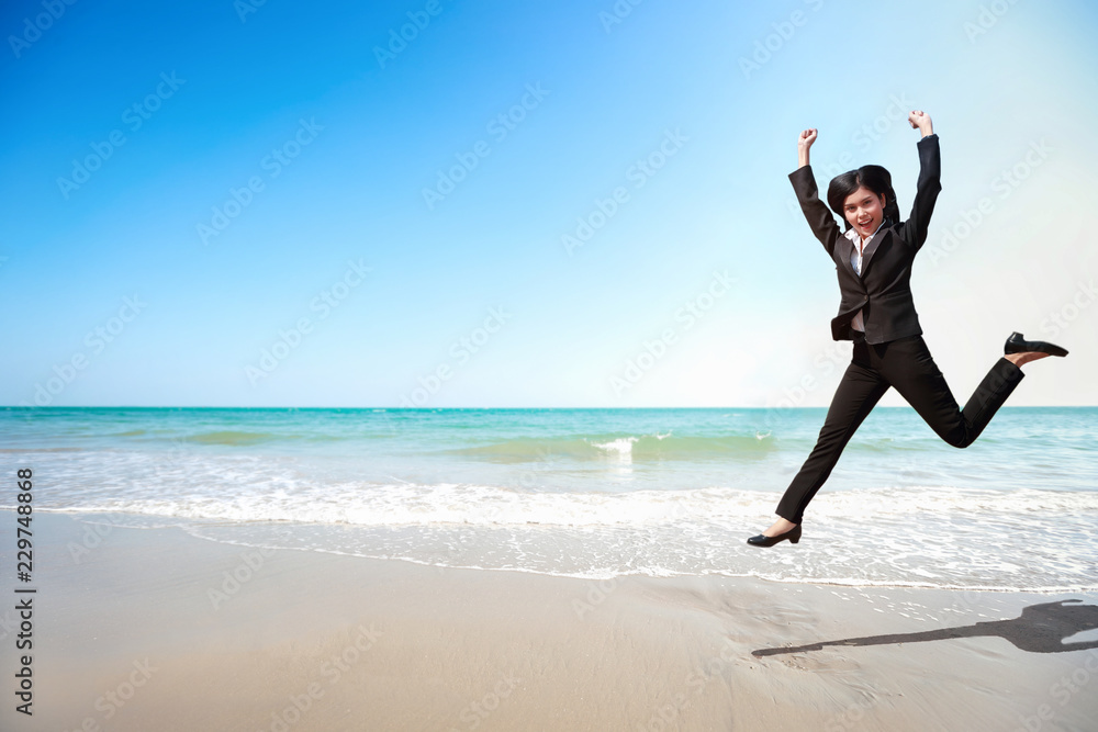 Business competition: businesswoman jumping with hand on the beach, meaning of winner Business competition: businesswoman jumping with hand on the beach, meaning of winner