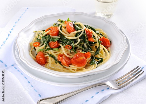 Fried spaghetti with dandelions, tomatoes and chilli photo