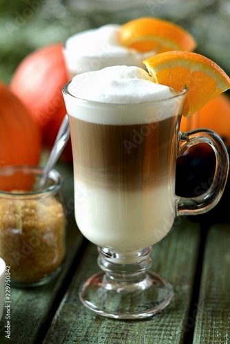 A latte macchiato garnished with a slice of orange photo