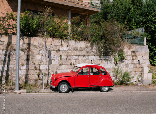Vintage red car on the street in the south of Europe near the sea