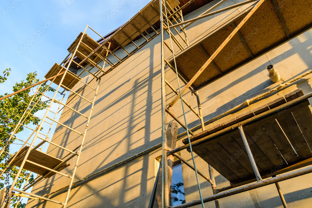 Insulation of the house with styrofoam. Scaffold on building Insulation of the house with styrofoam. Scaffold on building