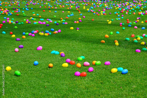 An Easter egg hunt with colorful plastic eggs on a green lawn