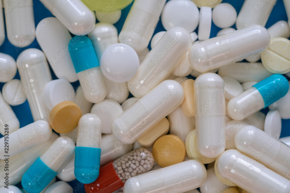 A lot of pills close up on a blue background A lot of pills close up on a blue background