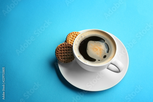 Cup with tasty aromatic coffee and cookies on color background