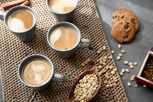 Cups with tasty aromatic coffee and cookies on table