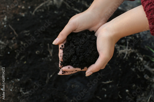 Woman holding black soil ou...