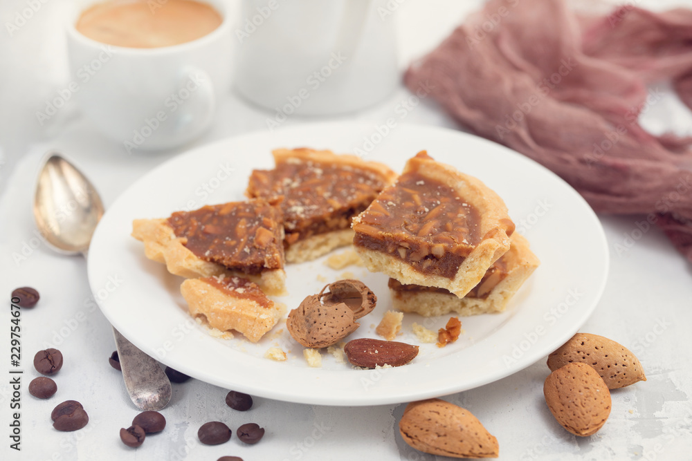 almond tart in small plate and cup of coffee almond tart in small plate and cup of coffee