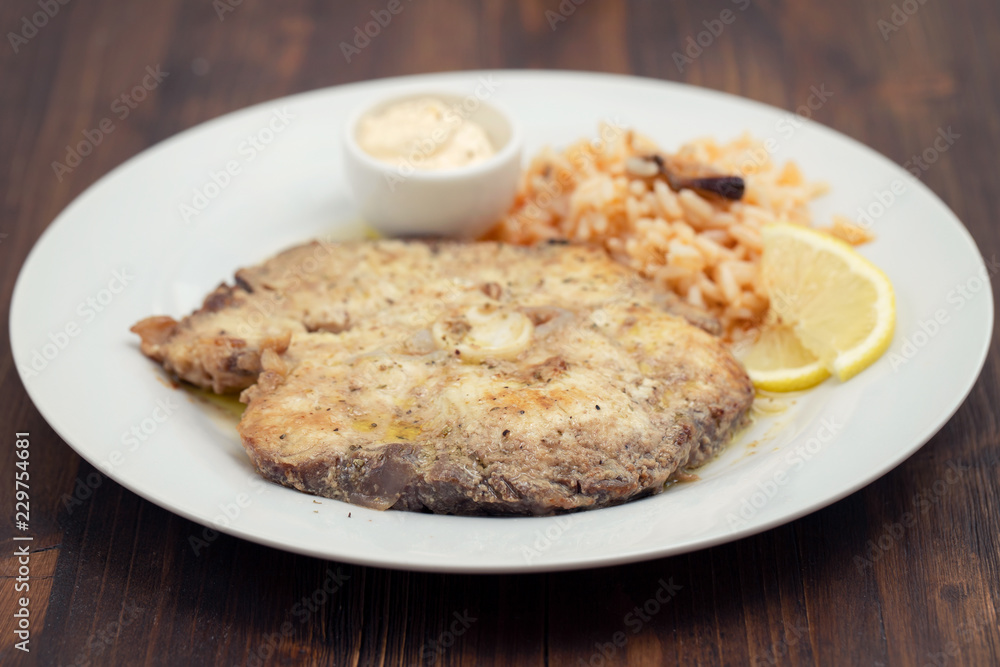 fried fish with rice and lemon on white plate fried fish with rice and lemon on white plate