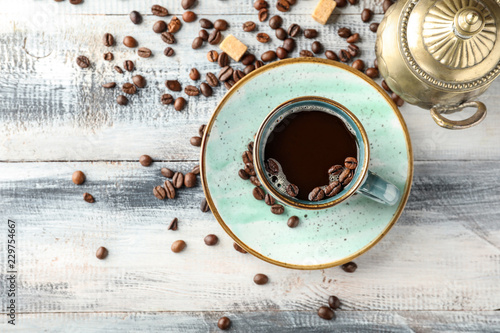 Composition with cup of hot coffee on wooden table