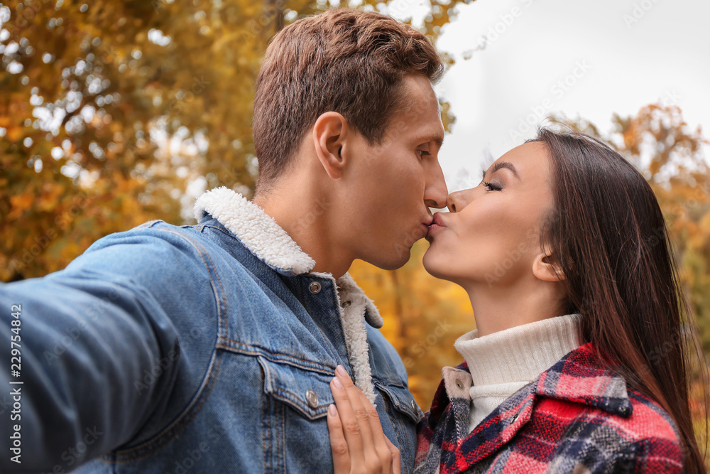 Fototapeta premium Happy loving couple taking selfie in autumn park