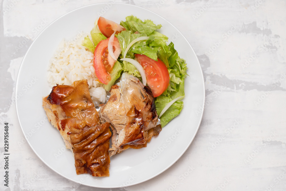roasted pork with boiled rice and salad on white plate