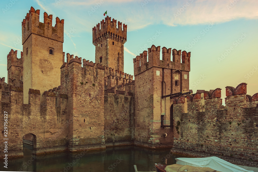 Medieval castle Scaliger on lake Garda in autumn sunrise, Sirmione, Italy