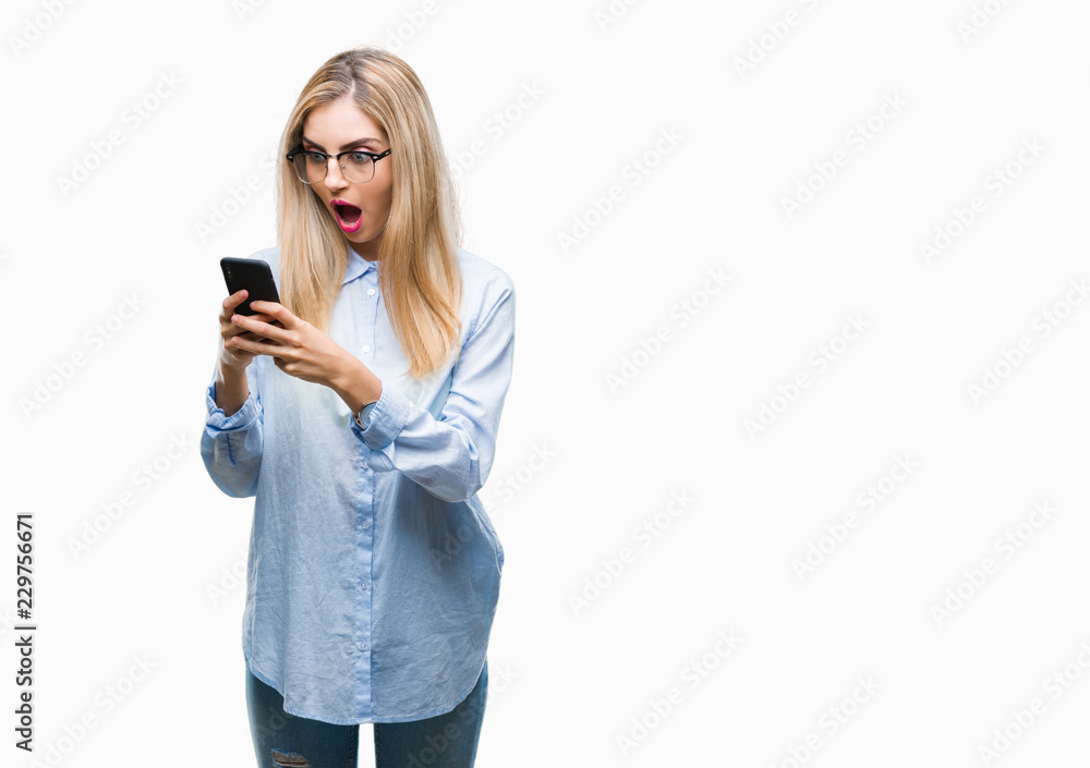 Young beautiful blonde business woman using smartphone over isolated background scared in shock with a surprise face, afraid and excited with fear expression Young beautiful blonde business woman using smartphone over isolated background scared in shock with a surprise face, afraid and excited with fear expression