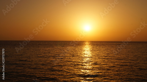 Sunset over Pacific Carribean beach showing dramatic red and yellow sky as sun sets 