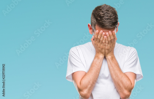 Young handsome man over isolated background with sad expression covering face with hands while crying. Depression concept.