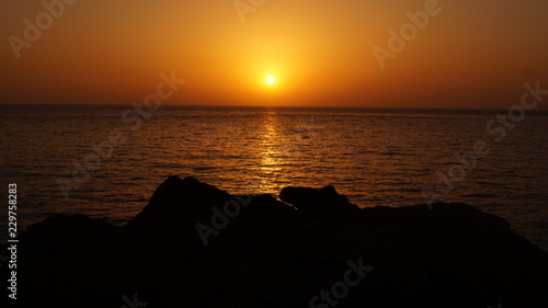 Sunset over Pacific Carribean beach showing dramatic red and yellow sky as sun sets 