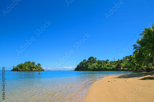 Fototapeta Naklejka Na Ścianę i Meble -  Albatross Island view from Upolu Island coast, pristine tropical coastal paradise with crystal pure blue waters in central Pacific Ocean, two samoans fishing in the shallow water