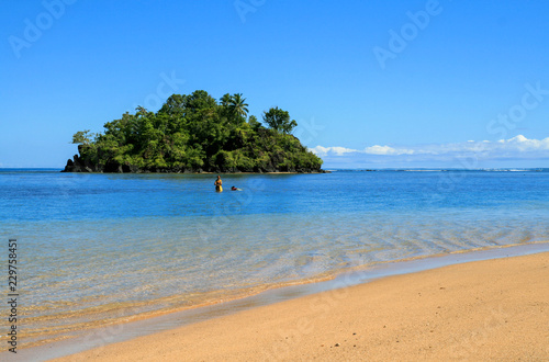 Fototapeta Naklejka Na Ścianę i Meble -  Albatross Island view from Upolu Island coast, pristine tropical coastal paradise with crystal pure blue waters in central Pacific Ocean, two samoans fishing in the shallow water