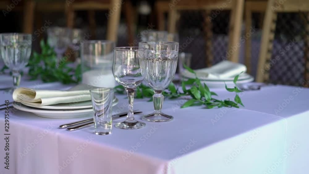 Banquet decorated table, with cutlery. Wedding decor in the banquet hall. Serving of a festive table, plate, napkin, knife, fork. Table setting decoration. Romantic Dinner or other events - wedding Banquet decorated table, with cutlery. Wedding decor in the banquet hall. Serving of a festive table, plate, napkin, knife, fork. Table setting decoration. Romantic Dinner or other events - wedding