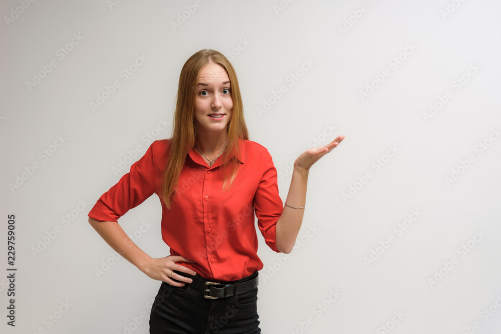 Studio portrait on the camera of a smiling beautiful girl with long hair talking on a white background with emotions. Studio portrait on the camera of a smiling beautiful girl with long hair talking on a white background with emotions.