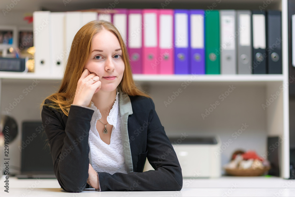 Concept manager in the office of a beautiful girl with long hair sitting at the table and talking. Concept manager in the office of a beautiful girl with long hair sitting at the table and talking.