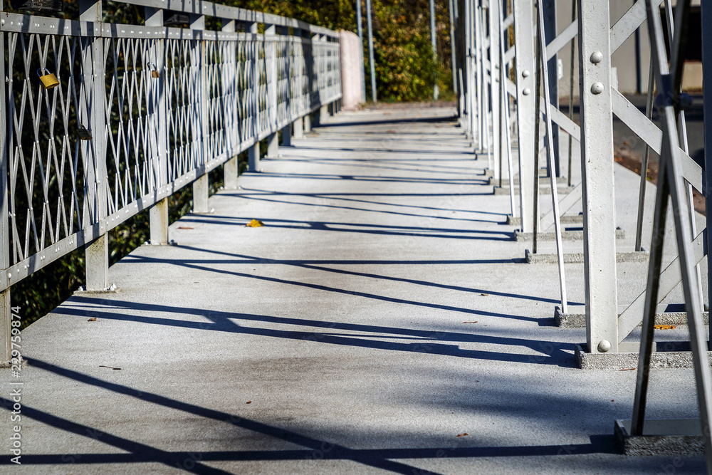 old metal bridge with railing and shadows old metal bridge with railing and shadows