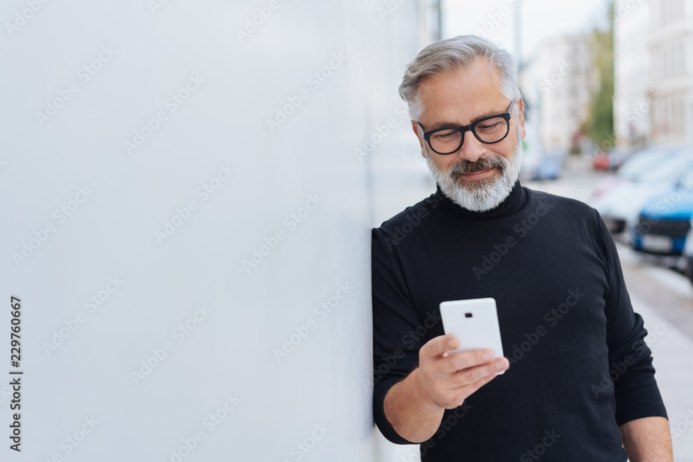 Smiling relaxed man reading a mobile message - obrazy, fototapety, plakaty 