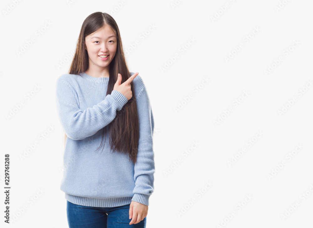 Young Chinese woman over isolated background cheerful with a smile of face pointing with hand and finger up to the side with happy and natural expression on face looking at the camera. Young Chinese woman over isolated background cheerful with a smile of face pointing with hand and finger up to the side with happy and natural expression on face looking at the camera.