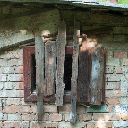 old rusty wooden hatch in old brick wall