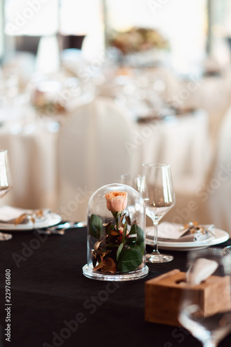 Rose in a glass flask. Wedding decor, interior. Festive. Banquet table