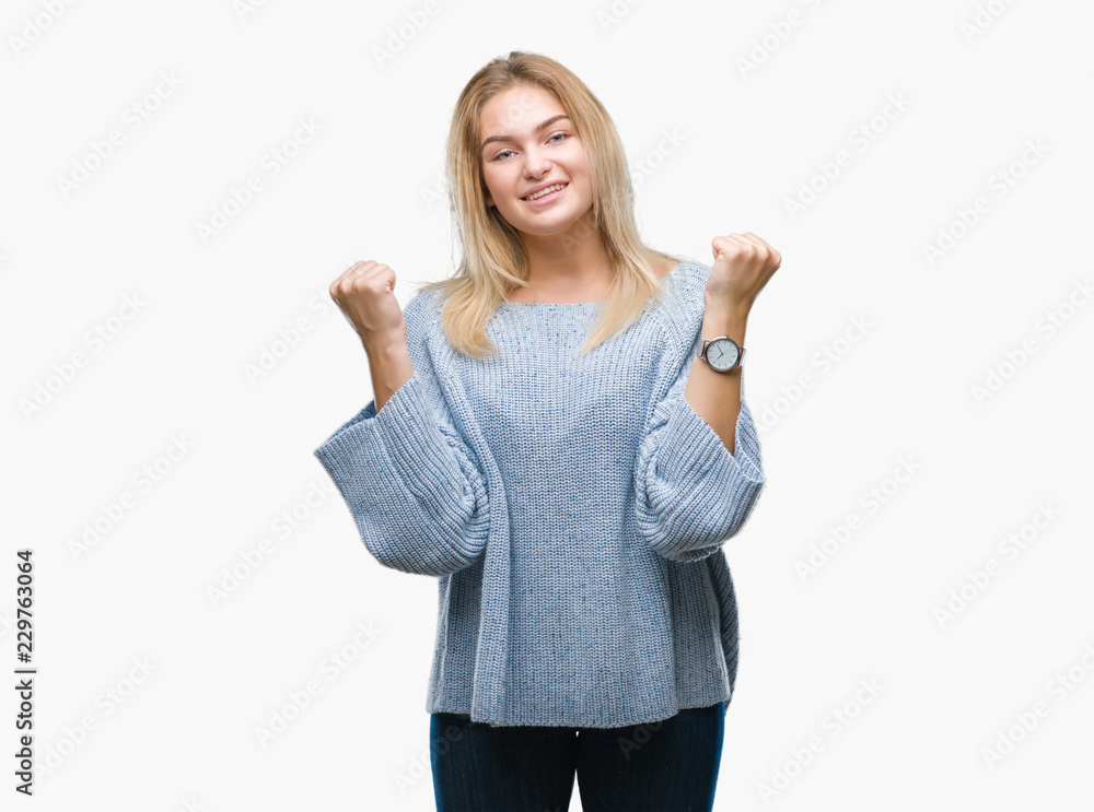 Young caucasian woman wearing winter sweater over isolated background celebrating surprised and amazed for success with arms raised and open eyes. Winner concept. Young caucasian woman wearing winter sweater over isolated background celebrating surprised and amazed for success with arms raised and open eyes. Winner concept.