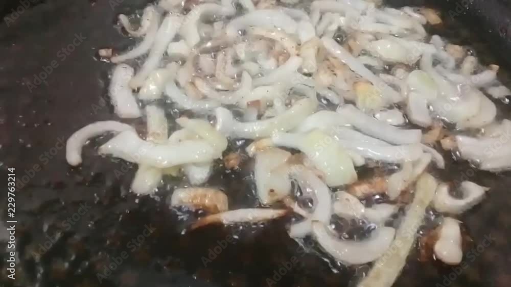 Frying chopped onions in boiling cooking oil on fry-pan with non-stick spatula or cookware Frying chopped onions in boiling cooking oil on fry-pan with non-stick spatula or cookware
