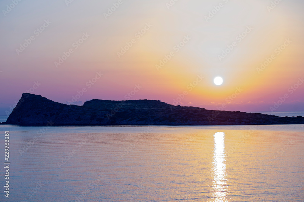 Naklejka premium Sunrise on the beach, early morning in Kolokitha island, Crete, Greece