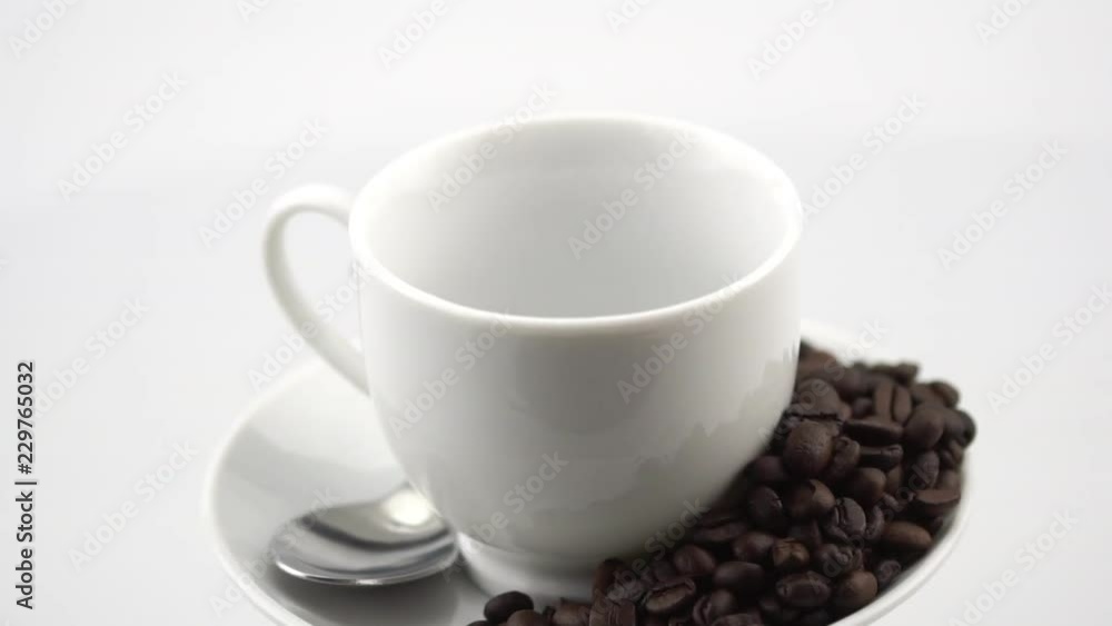 rotating of white coffee cup with coffee pouring into cup in slow motion rotating of white coffee cup with coffee pouring into cup in slow motion
