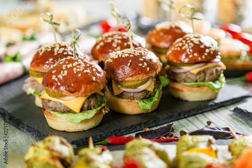 Set of meat burgers on black board on wooden table