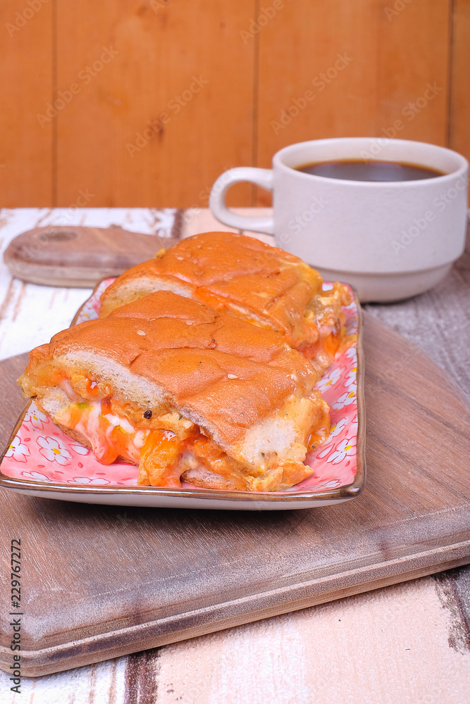 John bread with a cup off coffee on wooden cutting board