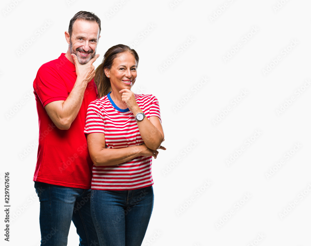 Naklejka premium Middle age hispanic couple in love over isolated background looking confident at the camera with smile with crossed arms and hand raised on chin. Thinking positive.