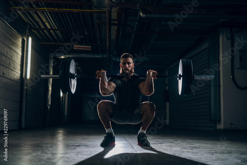 Cuadro en lienzo Muscular attractive caucasian bearded man doing front barbell squat in underground hallway