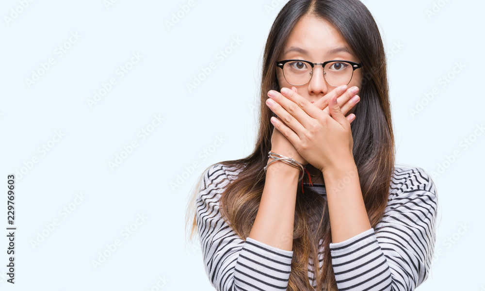 Young asian woman wearing glasses over isolated background shocked covering mouth with hands for mistake. Secret concept. Young asian woman wearing glasses over isolated background shocked covering mouth with hands for mistake. Secret concept.