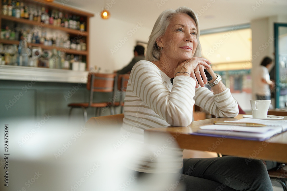 Senior woman thinking in a restaurant Senior woman thinking in a restaurant