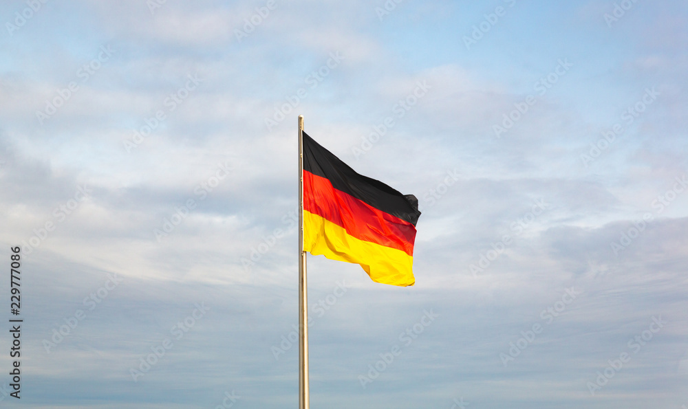German flag waved by the wind in a sunny day. German flag waved by the wind in a sunny day.