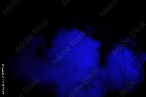 Bizarre forms of blue powder explode cloud on black background. Launched blue dust particles splash on black background.