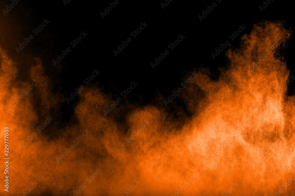 Abstract orange powder explosion on black background. Freeze motion of orange dust particles splash. Abstract orange powder explosion on black background. Freeze motion of orange dust particles splash.