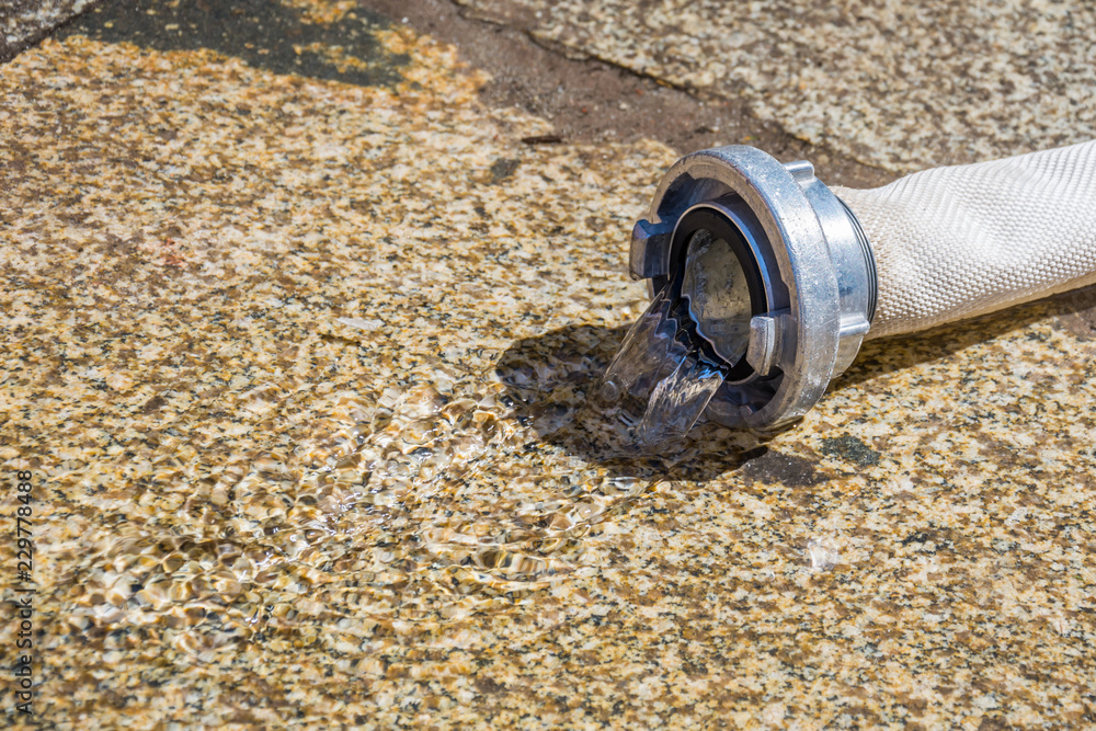 Water leaking from a fire hose to the ground Water leaking from a fire hose to the ground