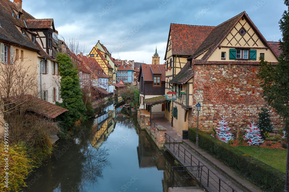 Traditional Alsatian half-timbered houses, church and river Lauch in Petite Venise or little Venice, old town of Colmar, decorated at christmas time, Alsace, France