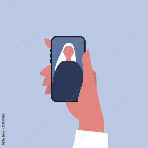 Social media. Hand holding a smartphone. An image of young female character on a mobile display