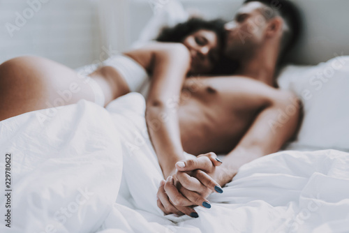 Young Beautiful Couple in Underwear Lying on Bed photo