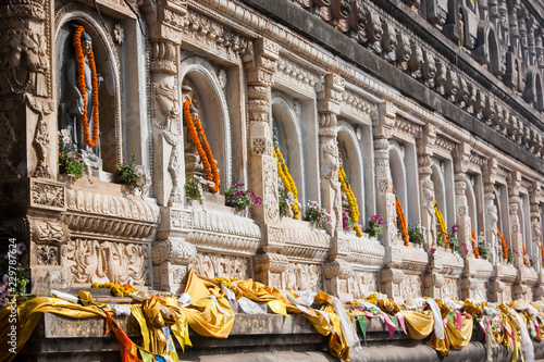 Buddha sculpture with french marigolds offered by pilgrims on the Mahabodhi Temple, Bodhgaya, Gaya, Bihar State, India photo