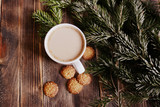 Coffee with milk, hot chocolate or cocoa with cinnamon stick in a Cup and fir branches. Winter hot drink for cold weather. New year and Christmas concept